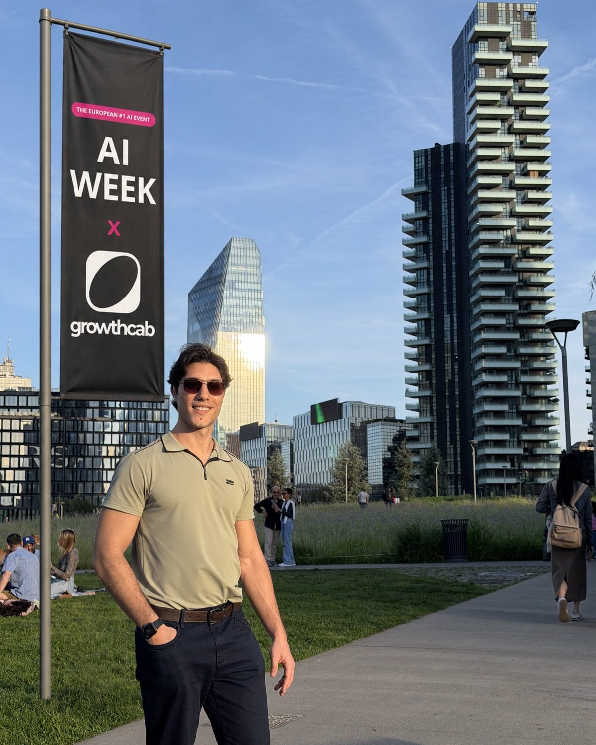 Federico Donatone in a Milan park beside an AI Week x Growth Cab street banner, with the Porta Nuova towers behind him