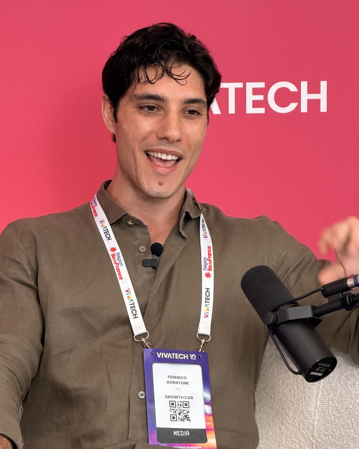 Federico Donatone, founder of Growth Cab, speaking into a studio microphone at VivaTech in Paris, with his media badge