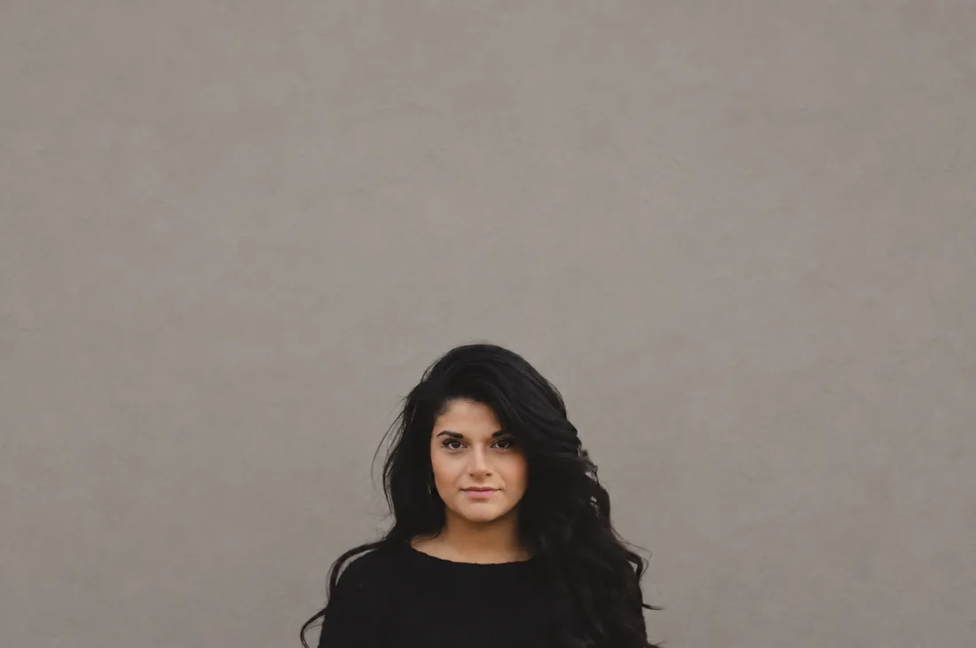 The same portrait after ChatGPT replaced the brick wall with a warm gray studio wall