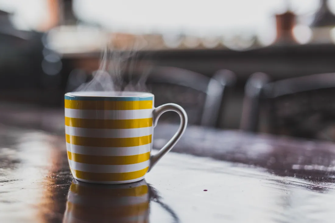 Yellow striped mug on a wet cafe table
